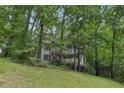 Two-story house with a white balcony, surrounded by lush green trees and vegetation at 3876 Winners Ct, Marietta, GA 30062