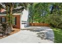 Spacious driveway leading to a two-car garage, complemented by a well-maintained lawn and privacy fencing at 5100 Sunset Maple Trl, Lilburn, GA 30047