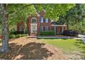 Charming brick home featuring manicured landscaping and mature trees, offering a picturesque and inviting setting at 5100 Sunset Maple Trl, Lilburn, GA 30047