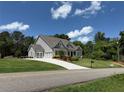 Beautiful home with a well-kept lawn, and a large driveway leading to a three-car garage at 6165 Namon Wallace Dr, Cumming, GA 30028