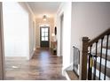 Inviting foyer featuring hardwood floors, neutral walls, and elegant lighting fixtures at 6165 Namon Wallace Dr, Cumming, GA 30028