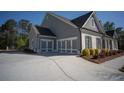 Side angle view of a home showcasing a three-car garage, gray siding and a concrete driveway at 6165 Namon Wallace Dr, Cumming, GA 30028