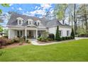 Charming white brick home featuring a manicured lawn, covered porch, and dormer windows at 1141 Ragley Hall Ne Rd, Brookhaven, GA 30319