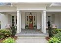 Inviting front porch with slate tile, white columns, and a warm-toned front door at 1141 Ragley Hall Ne Rd, Brookhaven, GA 30319