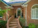 Inviting arched entrance with brick steps, lush greenery, and elegant brickwork at 225 Wexford Overlook Dr, Roswell, GA 30075
