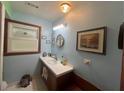 Comfortable bathroom features a vanity with sink, decorative mirror and small framed photos at 2932 Highway 20 Se, Conyers, GA 30013