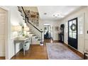 Inviting foyer featuring hardwood floors, a staircase, and a black front door at 5452 Tally Green Dr, Marietta, GA 30068