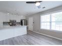 Bright kitchen featuring white cabinets, stainless steel appliances, and ample natural light from large windows at 1181 Mannbrook Dr, Stone Mountain, GA 30083
