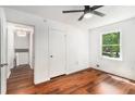 A bedroom featuring hardwood floors, neutral walls, a ceiling fan, and a window providing natural light at 240 Wellington Dr, Mcdonough, GA 30252
