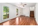 Bright living room with hardwood floors, large window views, and a staircase leading to the upper level at 240 Wellington Dr, Mcdonough, GA 30252