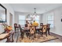 Inviting dining room featuring a decorative mirror, a wooden table, and elegant chandelier lighting at 3259 Baylor Cir, Mcdonough, GA 30253