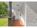 Close-up of the covered front porch with brick floor, dark wood support beam, and brick walls at 3406 Jackson Dr, Decatur, GA 30032