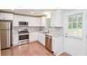 Modern kitchen featuring stainless steel appliances, white cabinets, granite countertops, and a door to the outside at 429 Landers Dr, Mableton, GA 30126