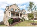An eye-level view of a two-story home with brick and siding, as well as a front porch and an attached two-car garage at 570 Eldridge Dr, Suwanee, GA 30024