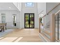 Bright foyer featuring soaring ceilings, hardwood floors, and black-framed glass front door at 1749 Patriots Nw Way, Kennesaw, GA 30152