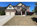 A charming two-story brick home with a red front door and manicured landscaping at 2030 Hydrangea Ln, Austell, GA 30106