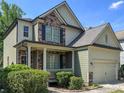 Well-maintained two-story home featuring stone accents, light green siding, and a two-car garage for convenience at 251 Shaw Dr, Acworth, GA 30102