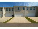 Rear view of townhomes with driveways leading to attached garages at 3407 Hidden Stream Ct, Stockbridge, GA 30281