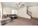Relaxing living room showcasing a staircase, large sofa, carpeted floors, and neutral walls at 517 Dasheill Ln, Atlanta, GA 30349