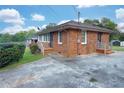 Rear of brick home with a spacious driveway, manicured lawn, and small wooden decks at 1083 Grace Dr, Forest Park, GA 30297