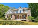 Inviting two-story brick home featuring a charming front porch with swing, set on a lush green lawn at 2870 Willow Wisp Way, Cumming, GA 30040
