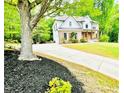 Lovely brick home with a welcoming porch and lush landscaping, set back from a long driveway lined with mulch at 2870 Willow Wisp Way, Cumming, GA 30040