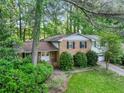 Two-story brick home with an attached garage, surrounded by lush landscaping at 3844 Lake Se Dr, Smyrna, GA 30082