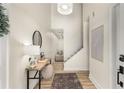 Inviting entryway with wood floors, a stylish console table, a decorative mirror, and a view of the staircase at 5250 Chemin De Vie, Atlanta, GA 30342