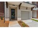 Close up of a townhouse front door and garage, showcasing the brickwork and carriage lights at 427 Burton Dr, Alpharetta, GA 30009