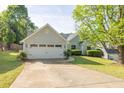 Charming light green home with a two car garage, manicured lawn, and concrete driveway at 635 Hickory Nobb, Sugar Hill, GA 30518