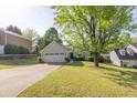 Charming light green home with a two car garage, manicured lawn, and concrete driveway at 635 Hickory Nobb, Sugar Hill, GA 30518