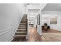 Inviting entryway showcasing hardwood floors, a staircase, and views into the dining and kitchen areas at 7554 Crawford Ct, Fairburn, GA 30213
