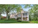 Back of home with a covered porch, stone accents, and manicured lawn at 454 Langley Oaks Dr, Marietta, GA 30067