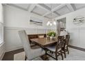 Formal dining room featuring wainscoting, coffered ceilings, and an elegant chandelier over a wood table at 4702 Jellico Dr, Powder Springs, GA 30127