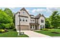 A stately stone home with a two-car garage and professionally landscaped yard offers exceptional curb appeal at 4702 Jellico Dr, Powder Springs, GA 30127