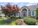 Beautiful stone front exterior with manicured landscaping, arched entryway, and decorative windows at 6725 Polo Dr, Cumming, GA 30040