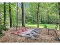 Fun backyard game area featuring a large checker board surrounded by mature trees at 989 Pinfeather Ct, Lawrenceville, GA 30043