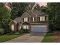 Inviting two-story home with a stone accent, lush landscaping, and an attached two car garage at 989 Pinfeather Ct, Lawrenceville, GA 30043