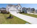 Attractive two-story farmhouse-style home with a long driveway, a lush green lawn, and colorful landscaping at 146 Citrine Way, Acworth, GA 30101