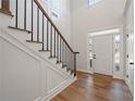 Bright foyer with hardwood floors, staircase with a black railing, and a paneled wall at 3850 Laurel Nw Dr, Acworth, GA 30101