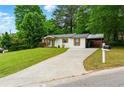 View of the house from a long driveway with a carport and green lawn at 2804 Hall Se Dr, Smyrna, GA 30082