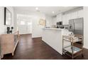 Modern kitchen with white cabinetry, stainless steel appliances, hardwood floors and bar top at 813 Ambient Sw Way, Atlanta, GA 30331