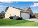 Rear-side of a single-story home with a two-car garage, lawn, and privacy fence at 4410 Chaney Ct, Cumming, GA 30028