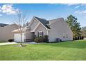 Side view of a single-story home with a two-car garage and well-maintained landscaping at 4410 Chaney Ct, Cumming, GA 30028