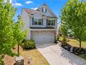 Attractive two-story home featuring a two-car garage, brick accents, and well-landscaped front yard with mature trees at 6170 Weddington Dr, Cumming, GA 30040