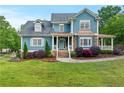 Charming two-story home with manicured lawn, stone accents and inviting front porch with beautiful landscaping at 65 Maude White Rd, Kingston, GA 30145