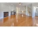 Spacious living room with gleaming hardwood floors, a fireplace, and access to staircase at 2919 Camplay Dr, Suwanee, GA 30024