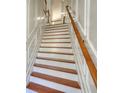 Elegant staircase featuring wooden treads and risers, contrasted by white trim and wooden handrail at 2919 Camplay Dr, Suwanee, GA 30024