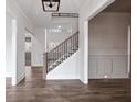 Inviting foyer featuring wood floors, staircase with black iron railings, and neutral wall colors, creating a bright and welcoming space at 3390 Hillshire Dr, Cumming, GA 30028