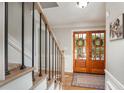 Bright entryway featuring wooden double doors, hardwood floors, and a staircase at 4540 Saddle Se Ct, Smyrna, GA 30082